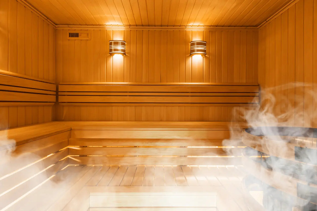 Person relaxing on a wooden bench in a warm traditional sauna